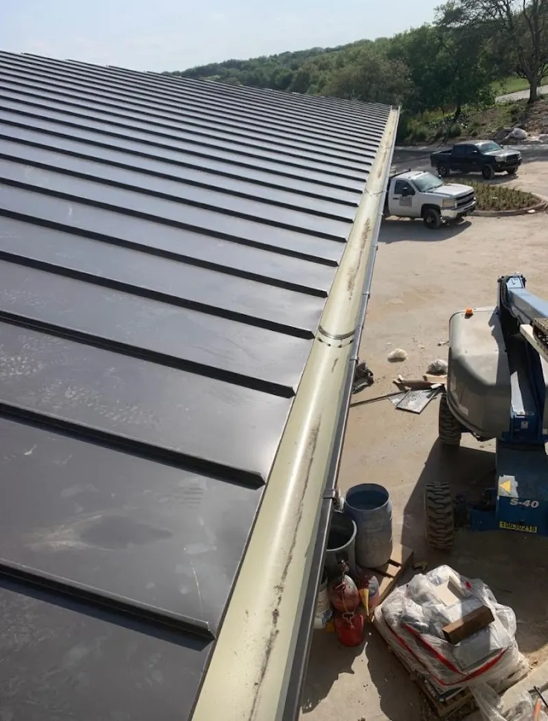 Standing seam panel and gutter detail on a metal roofing jobsite in Stayton